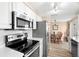 Updated kitchen with stainless appliances, white cabinets, and an adjacent dining area at 2146 Society Dr, Holiday, FL 34691