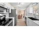 Modern kitchen featuring stainless steel appliances, a white backsplash, and an open layout at 2146 Society Dr, Holiday, FL 34691