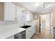 Modern kitchen with stainless steel appliances, white cabinetry, and a view into an adjacent room at 2146 Society Dr, Holiday, FL 34691