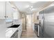 Bright kitchen featuring updated appliances, white cabinetry, and light, wood-look floors at 2146 Society Dr, Holiday, FL 34691