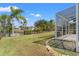 A spacious backyard with views of a serene pond and tropical landscaping at 2250 Long View Cir, Brooksville, FL 34604
