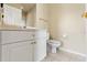 Bright bathroom features a toilet, vanity with white cabinets, and neutral wall and flooring at 2250 Long View Cir, Brooksville, FL 34604