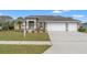 Beautiful home featuring a three car garage, front lawn, and attractive landscaping at 2250 Long View Cir, Brooksville, FL 34604