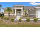 Charming home featuring a covered front entrance with columns and a well-manicured lawn with palm trees at 2250 Long View Cir, Brooksville, FL 34604