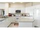 Well-lit kitchen with white cabinetry, tile flooring, modern appliances, and center island at 2250 Long View Cir, Brooksville, FL 34604
