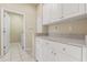 Functional laundry room with ample cabinet space and tile flooring at 2250 Long View Cir, Brooksville, FL 34604