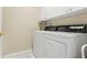 Functional laundry room with white appliances and cabinets above at 2250 Long View Cir, Brooksville, FL 34604