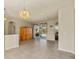 Spacious living room with tiled flooring, a classic chandelier, and sliding glass doors leading to a covered patio at 2250 Long View Cir, Brooksville, FL 34604