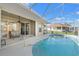A kidney-shaped pool is attached to a covered patio, creating a luxurious outdoor living space at 2250 Long View Cir, Brooksville, FL 34604