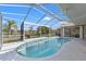 Outdoor screened-in pool with clear blue water and a view of a lake at 2250 Long View Cir, Brooksville, FL 34604