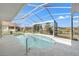 A kidney-shaped pool is enclosed in a screened lanai, creating a relaxing outdoor living space at 2250 Long View Cir, Brooksville, FL 34604