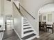 Bright home interior featuring a staircase with wood treads and an adjacent archway leading to an outdoor pool area at 2403 Hawthorne Rd, Spring Hill, FL 34609