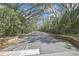 Long driveway entrance featuring brick columns with a canopy of lush, mature trees providing shade at 2602 Fiddlestick Cir, Lutz, FL 33559