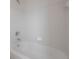 Clean, all-white tiled bathtub and shower combination with chrome fixtures at 3025 Chessington Dr, Land O Lakes, FL 34638