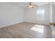 Spacious bedroom featuring wood-look flooring, a ceiling fan, and natural light from the window at 3025 Chessington Dr, Land O Lakes, FL 34638