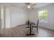 Bedroom with wood-look floors, ceiling fan, and natural light from the window at 3025 Chessington Dr, Land O Lakes, FL 34638