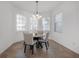 Well-lit dining area with modern chandelier and multiple windows at 3025 Chessington Dr, Land O Lakes, FL 34638