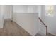 Hallway with wood floors leading to staircase with wood railing at 3025 Chessington Dr, Land O Lakes, FL 34638