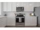 A pristine kitchen showcasing stainless steel appliances, white cabinetry, and light countertops at 3025 Chessington Dr, Land O Lakes, FL 34638