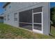 View of a screened patio with an exterior door and visible grill at 3025 Chessington Dr, Land O Lakes, FL 34638