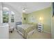 Bright bedroom with high ceiling, large window, light green accent wall, and neutral carpet at 3042 Branch Dr, Clearwater, FL 33760