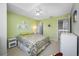 Bedroom features neutral carpeting, green accent wall, ceiling fan, and modern decor at 3042 Branch Dr, Clearwater, FL 33760