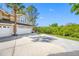 Charming tan home featuring a spacious driveway, well-manicured lawn and bright blue skies at 3042 Branch Dr, Clearwater, FL 33760