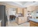 Well-lit eat-in kitchen with light wood cabinets, stainless steel refrigerator, and view into dining area at 3042 Branch Dr, Clearwater, FL 33760