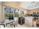 Eat-in kitchen with stainless steel appliances, wine cooler, and natural light from large windows at 3042 Branch Dr, Clearwater, FL 33760