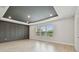 Bedroom with a tray ceiling, wood-look floors, and an accent wall at 3404 S Omar Ave, Tampa, FL 33629