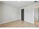 Bedroom with light wood flooring, gray door, and white walls at 3404 S Omar Ave, Tampa, FL 33629
