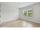 Bedroom with wood flooring, two windows with nature view, and white walls at 3404 S Omar Ave, Tampa, FL 33629