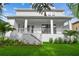 Charming two-story home with a white exterior, covered porch, and a lush green lawn at 3404 S Omar Ave, Tampa, FL 33629