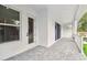 A white porch with gray pavers, a white door, and large windows fills this outdoor space at 3404 S Omar Ave, Tampa, FL 33629