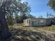 Image of a distressed single-story home with cinder block construction and overgrown landscaping at 342 Lettie Ln, Seffner, FL 33584