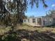 Image of a distressed single-story home with cinder block construction and overgrown landscaping at 342 Lettie Ln, Seffner, FL 33584