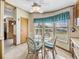 Bright breakfast nook featuring a glass table, wicker chairs, large windows, and a ceiling fan at 35925 Hermoso Ln, Zephyrhills, FL 33541