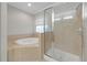 Bathroom showcases soaking tub with tile surround, and a glass-enclosed shower at 3622 Wiregrass Rd, New Port Richey, FL 34655