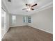 Spacious bedroom with neutral walls, plush carpeting, tray ceiling, and ceiling fan at 3622 Wiregrass Rd, New Port Richey, FL 34655