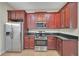 This kitchen offers stainless steel appliances, dark granite countertops, and dark wood cabinets at 3622 Wiregrass Rd, New Port Richey, FL 34655