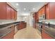 Spacious kitchen with stainless steel appliances, dark granite countertops, and dark wood cabinets at 3622 Wiregrass Rd, New Port Richey, FL 34655