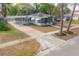 Single-story home with a screened porch and carport, highlighted by a brick driveway and mature trees at 560 80Th N Ave, St Petersburg, FL 33702
