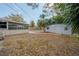 Spacious backyard featuring a screened porch, lush landscaping, and a storage shed at 560 80Th N Ave, St Petersburg, FL 33702