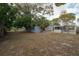 Large backyard with a storage shed, partially fenced, and mature trees at 560 80Th N Ave, St Petersburg, FL 33702