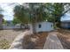 View of a fenced backyard featuring a shed with trees and a stone walkway at 560 80Th N Ave, St Petersburg, FL 33702