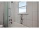 Clean bathroom with a window over the tub and shower combo, and a gray and white accent tile stripe at 560 80Th N Ave, St Petersburg, FL 33702