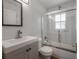 Bright bathroom with a single vanity, framed mirror, and a glass enclosed tub and shower at 560 80Th N Ave, St Petersburg, FL 33702