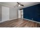 Bedroom with wood-look flooring and a bold blue accent wall at 560 80Th N Ave, St Petersburg, FL 33702