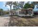 Quaint home with a screened porch and carport, complemented by a brick driveway and lush landscaping at 560 80Th N Ave, St Petersburg, FL 33702