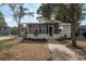 Charming single-story home with a well-manicured lawn and brick pathway leading to the screened porch at 560 80Th N Ave, St Petersburg, FL 33702